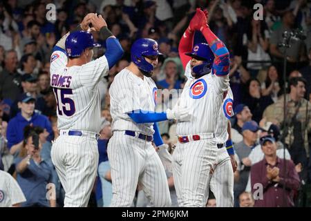 Chicago Cubs third baseman David Bote (13), shortstop Zach McKinstry (6)  and right fielder Nelson Velazquez celebrate the team's 2-1 win in a  baseball game against the Miami Marlins, Tuesday, Sept. 20