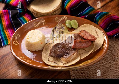 Roast meat (carne asada) very popular dish in northern Mexico, also called Asado, Discada or Parrillada, is a cooking technique in which food is expos Stock Photo