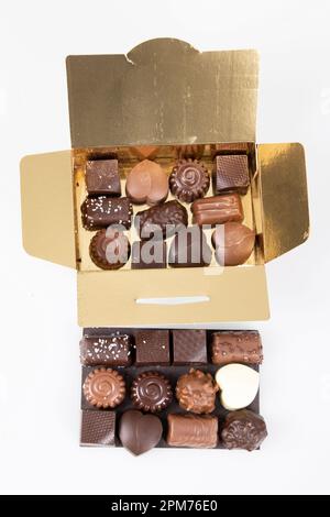 Assortment of fine chocolates candies in small golden open gift gold box of dark milk chocolate Stock Photo