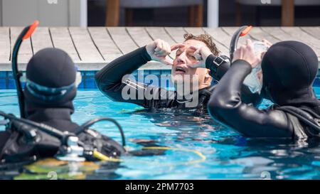 Scuba dive instructor teaching and explaining to students the regulator ...