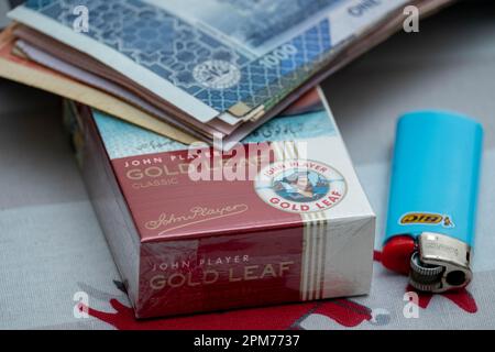 gold leaf cigarette price in pakistan full pack Gold Leaf Cigarette with Pak currency. 1000 rupees Bank notes. inflation  and economy concept Stock Photo