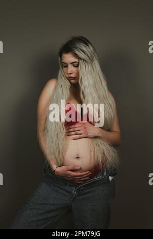 Pregnant woman in bra and jeans hi-res stock photography and