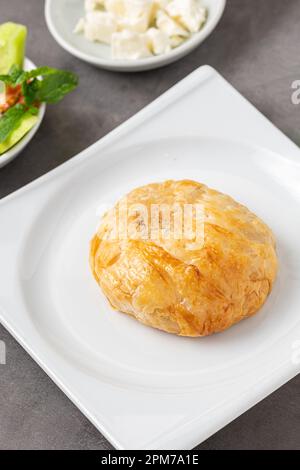 Izmir boyoz on a white porcelain plate on a stone table Stock Photo