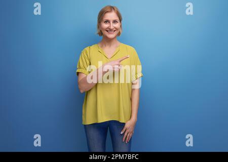 middle aged woman with insight points finger to the side in studio Stock Photo