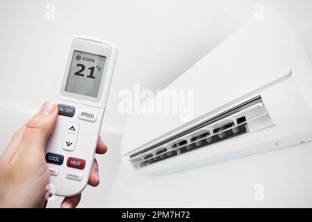 Air conditioner at home, hand with remote control. Air climate conept Stock Photo