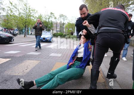 Activist Miriam Tinto of 'Ultima Generazione' is removed by law enforcement officers during a traffic blockade. Stock Photo