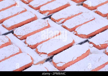 France, Marne, Reims, Maison Fossier (Living Heritage company), biscuit factory, manufacture of pink biscuits from Reims (champenoise specialties) created at the end of the 17th century, dusting with icing sugar Stock Photo