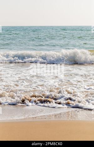 Vertical image of waves breaking onto a sandy beach. Swanage, Dorset, England, UK Stock Photo
