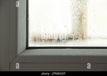 Moisture and condensation on the window in the apartment, water on the glass Stock Photo