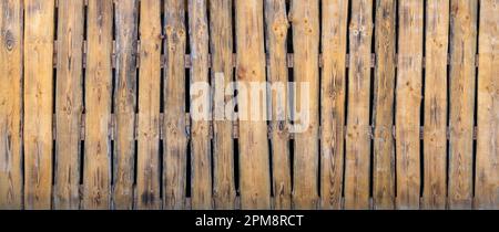 Old yellow-brown plank partition wall against dark background Stock Photo