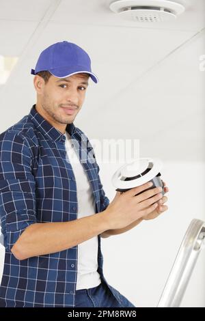 young repairman changing filter for air conditioner Stock Photo