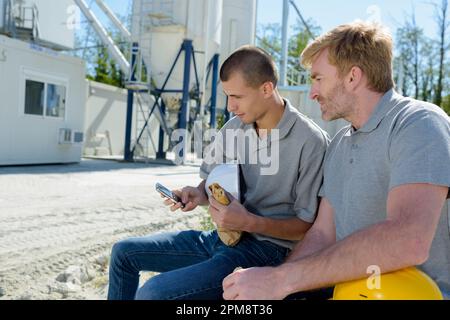 two construction workers eating lunch Stock Photo