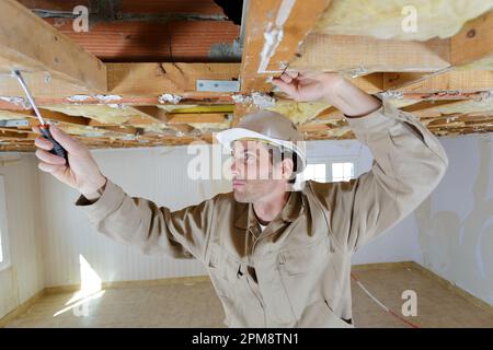 a male working on ceiling Stock Photo