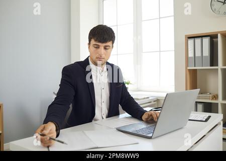 Business man on online meeting with clients writing making notes during conversation in laptop. Stock Photo