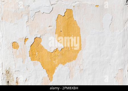 Abstract texture and detail of peeling paint and plaster on the wall of an old house. Stock Photo