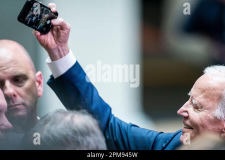 US President Joe Biden takes selfies with members of the audience after delivering his keynote speech at Ulster University in Belfast, during his visit to the island of Ireland. Picture date: Wednesday April 12, 2023. Stock Photo