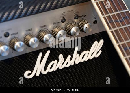 A classic Marshall guitar amp with a guitar leaning against it at home. Theme: adult hobbies, playing guitar, amp manufacturer, amplifier company Stock Photo