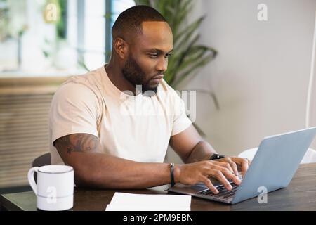Young business black african american man working from home on table with notebook computer laptop Stock Photo