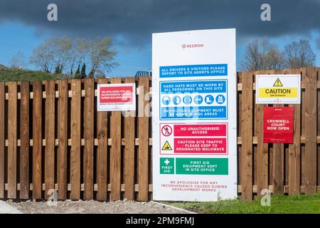 A collection of signs and health and safety notices on a board around a building construction development site Stock Photo