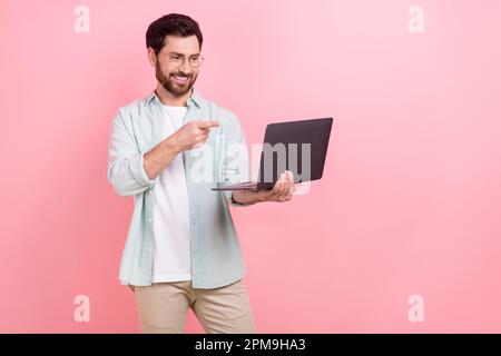 Photo portrait of attractive young man gadget finger point screen video call dressed stylish blue outfit isolated on pink color background Stock Photo
