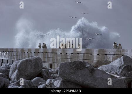 Porto, Portugal - December 31, 2015: People watching the storm in the Douro river mouth pier, north of Portugal. Used infrared filter. Stock Photo