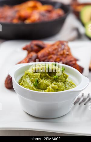 Grilled chicken legs and wings with guacamole, frish salad and spicies Stock Photo