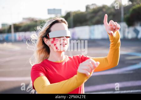 Young woman using virtual reality glasses to follow her team and cheer with new technologies. Concept: fans, virtual reality glasses, technology Stock Photo