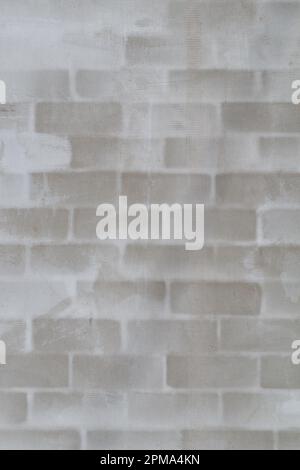 Piece of brick wall under plaster. Brick block wall background with reinforcing mesh for wall plastering. White gray stucco and brick wall texture. Stock Photo
