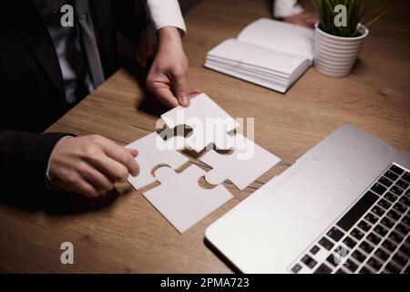 Crop close up of businessman hold pieces of jigsaw puzzle think of business problem solution or idea. Stock Photo