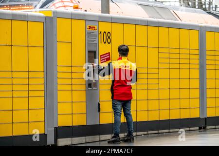 DHL Parcel Station, DHL employee operates the Parcel Pick-up and Dispatch Station, Frankfurt am Main, Hesse, Germany, Stock Photo