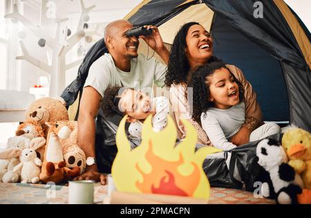 Family, living room and tent with children, games and toys for bonding, love and playing together. Parents, girl kids and laughing with mom, dad or Stock Photo