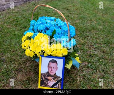 A photograph of Evgeny Yakovlev, 42, a soldier killed by Russian forces on eastern Ukrainian front in a combat, on the Lisove Cemetery in Kyiv, the capital of Ukraine on April 12, 2023. Lisove Cemetery is were most of fallen army-men from Kiev are buried. As the full scale invasion of Ukraine by the Russian forces continuous, the fight in the East of Ukraine causes very high casualty rate, though the exact numbers are unknown. Ukraine prepares for a spring offensive to retake the land occupied by Russia. (Photo by Dominika Zarzycka/Sipa USA) Stock Photo