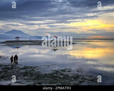 Sunrise on beautiful Sanur beach with mountains and pagodas.  A tropical sunrise in Bali Stock Photo