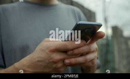 Close-Up Shot of Male Hands Using Smartphone Outdoors - Technology and Connectivity Concept Stock Photo
