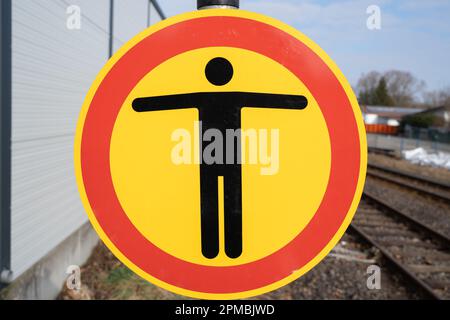 Round no passage sign on train station with rails in background Stock Photo