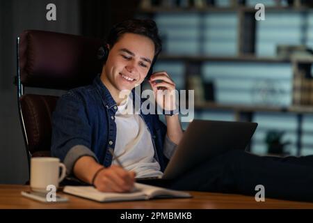 Cheerful young man employee working night shift at office Stock Photo