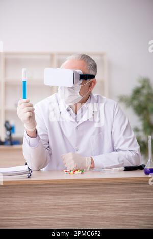 Old chemist wearing virtual glasses at the lab Stock Photo