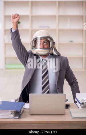 Young businessman employee wearing spacesuit at workplace Stock Photo