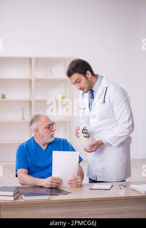 Two doctors in remuneration concept Stock Photo