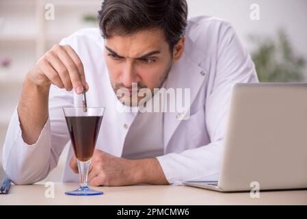 Young chemist examining soft drink at the lab Stock Photo