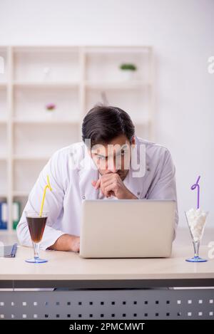 Young chemist examining soft drink at the lab Stock Photo