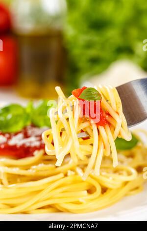 Spaghetti meal from Italy eat eating on a fork pasta lunch with tomato sauce portrait format Stock Photo