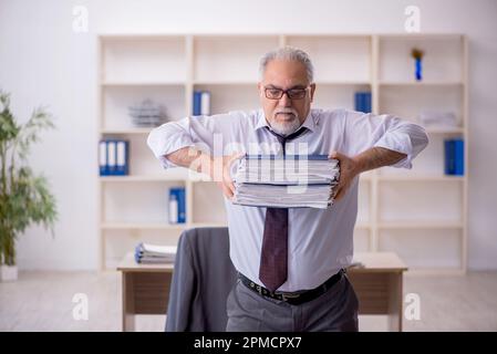 Old employee doing sport exercises during break Stock Photo