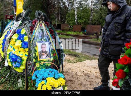 April 12, 2023, Kyiv, Ukraine: A friend pays respect during the funeral of Evgeny Yakovlev, 42, a soldier killed by Russian forces on eastern Ukrainian front in a combat, at the Lisove Cemetery. Lisove Cemetery is where most of the fallen army-men from Kiev are buried. As the full scale invasion of Ukraine by the Russian forces continuous, the fight in the East of Ukraine causes very high casualty rate, though the exact numbers are unknown. Ukraine prepares for a spring offensive to retake the land occupied by Russia. (Credit Image: © Dominika Zarzycka/SOPA Images via ZUMA Press Wire) EDITORIA Stock Photo