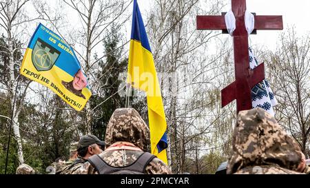 April 12, 2023, Kyiv, Ukraine: A cross, Ukrainian flag and a battalion flag are seen during the funeral of Evgeny Yakovlev, 42, a soldier killed by Russian forces on eastern Ukrainian front in a combat, at the Lisove Cemetery in Kyiv. Lisove Cemetery is where most of the fallen army-men from Kiev are buried. As the full scale invasion of Ukraine by the Russian forces continuous, the fight in the East of Ukraine causes very high casualty rate, though the exact numbers are unknown. Ukraine prepares for a spring offensive to retake the land occupied by Russia. (Credit Image: © Dominika Zarzycka/S Stock Photo