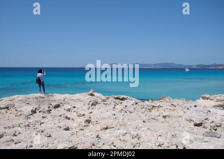 Madrid, Spain. 11th Apr, 2023. A woman takes photos at the seaside in Formentera Island of the Balearic Islands, Spain, April 11, 2023. Credit: Meng Dingbo/Xinhua/Alamy Live News Stock Photo