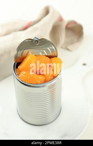 Canned Orange Tangerine in Swwt Syrup. Pickled Preserved Mandarin Fruit in the Can on White Table. Stock Photo