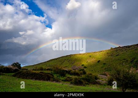 Rainbow on a dark stormy sky background photographed in Israel Stock Photo
