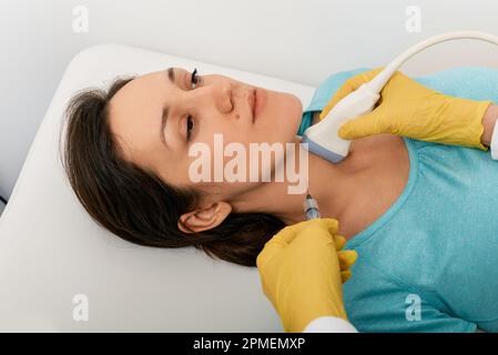 Thyroid nodule biopsy. Adult woman during fine needle aspiration biopsy guided ultrasonic and ultrasound specialist Stock Photo