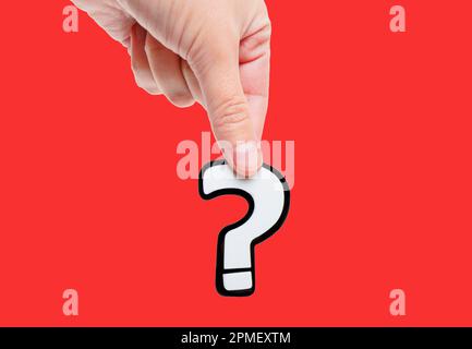 W/question Hand Fingers pinch-holding white question marks isolated on red representing ...